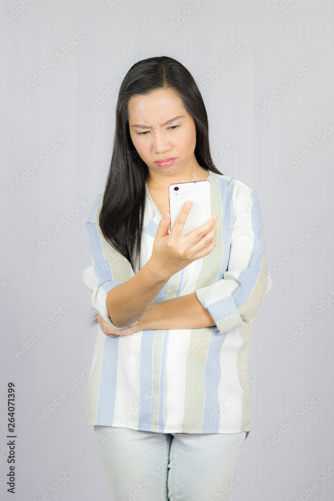 cute beautiful woman in shirt acting playing on phone. Isolated on gray background cute beautiful woman in shirt acting playing on phone. Isolated on gray background
