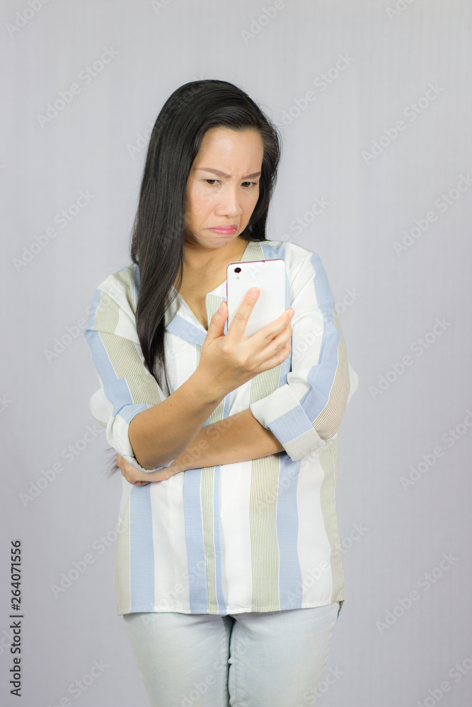 cute beautiful woman in shirt acting playing on phone. Isolated on gray background cute beautiful woman in shirt acting playing on phone. Isolated on gray background