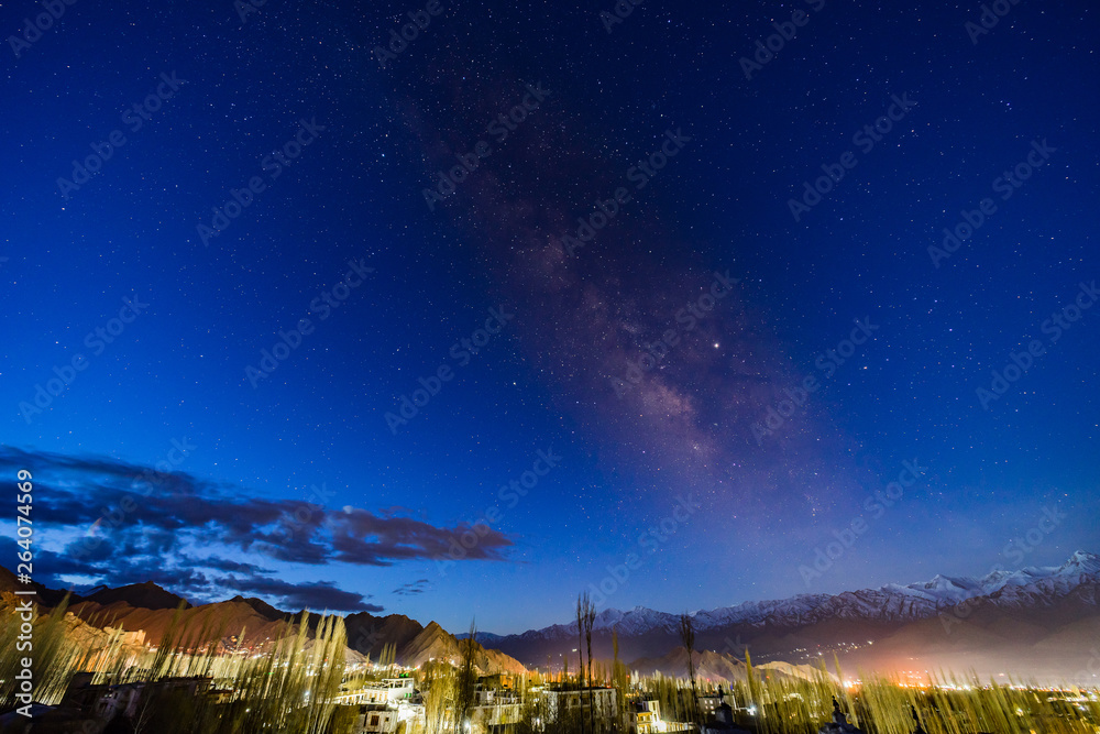 Panorama of arching Milky Way galactic center over the mountain at Leh city, Ladakh, Jammu and Kashmir, India.