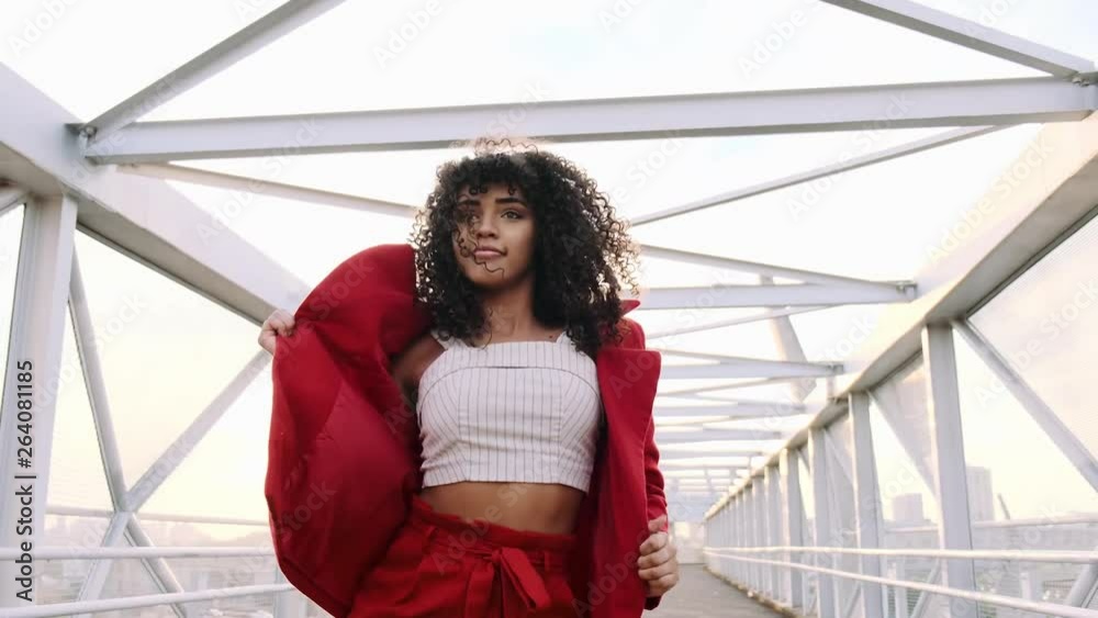 Happy beautiful afro-american woman walking and dancing outdoor. Young mixed race carefree girl enjoys the day and dancing in slow motion. Black lady walking on pedestrian walkway. Steadicam shot. Happy beautiful afro-american woman walking and dancing outdoor. Young mixed race carefree girl enjoys the day and dancing in slow motion. Black lady walking on pedestrian walkway. Steadicam shot.
