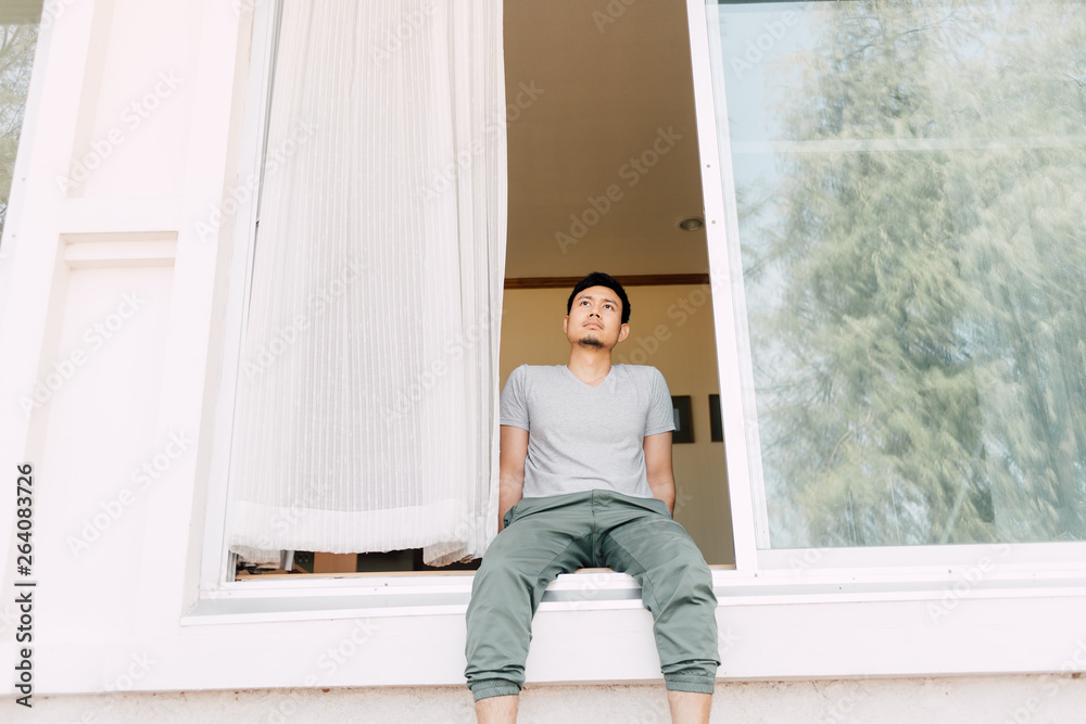 Man sit and relax at the front door of the house in summer. Concept of single man life. Man sit and relax at the front door of the house in summer. Concept of single man life.