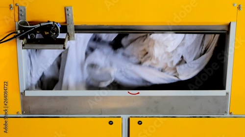 Clothes are tossed around in a large drying machine, spinning in a black background. photo