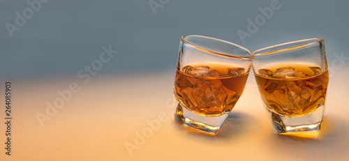 Whiskey glass and ice with decorative lights on a white gradient background. Celebration drinking concept. Text input area