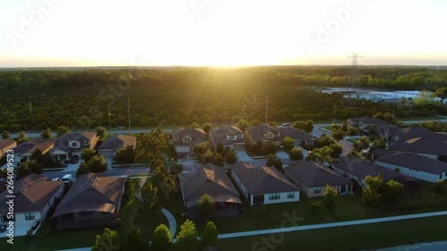 Quick horizontal dolly over homes and a farm during the sunset photo