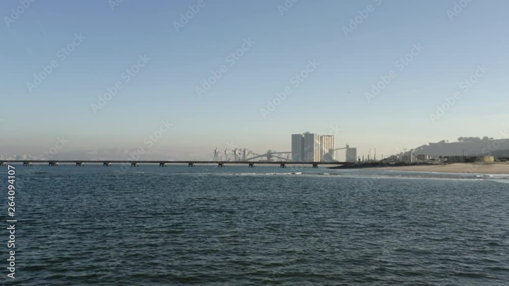 Cereal silos by the sea. Approach drone shot. Lisbon city on the background. Cereal silos by the sea. Approach drone shot. Lisbon city on the background.