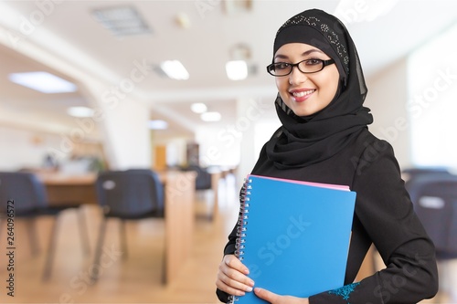 Close-up Beautiful Young Muslim Woman with notebooks  on blurred background