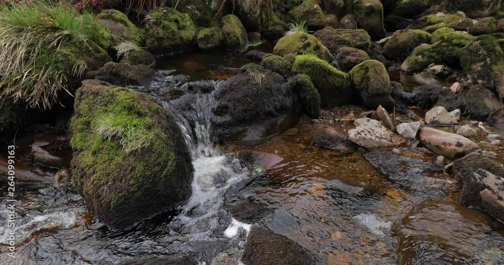 Slow motion scene of a Gentle mountain stream flowing around rocks on the Isle of Arran in Scotland. Slow motion scene of a Gentle mountain stream flowing around rocks on the Isle of Arran in Scotland.
