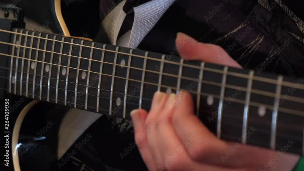 Slow pan around person twanging guitar strings with two fingers Slow pan around person twanging guitar strings with two fingers
