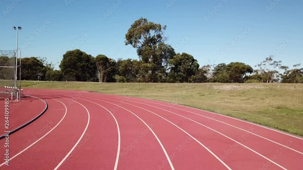 First person perspective running around first corner of a red athletics rubber track