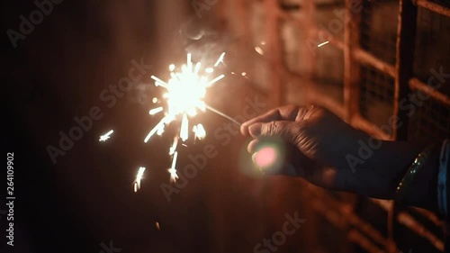 Hand holding firecrackers at night celebrating New year, Indian festivals photo