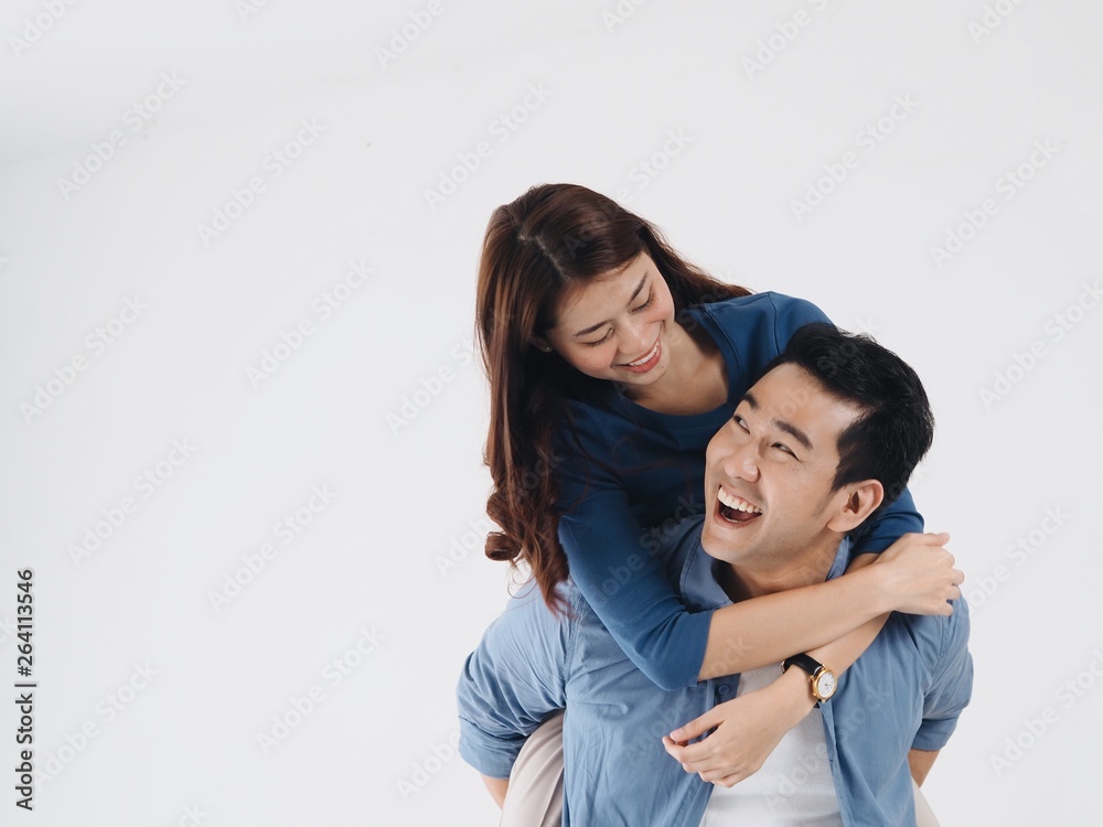 Happy Asian man carrying his girlfriend on the back over white background,copy space. Happy Asian man carrying his girlfriend on the back over white background,copy space.