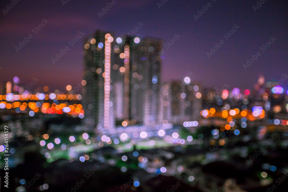 Blurred background of lights from various buildings, with a variety of colorful bokeh