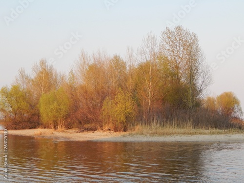  Scenic view of an island in the middle of the river before sunset in spring.