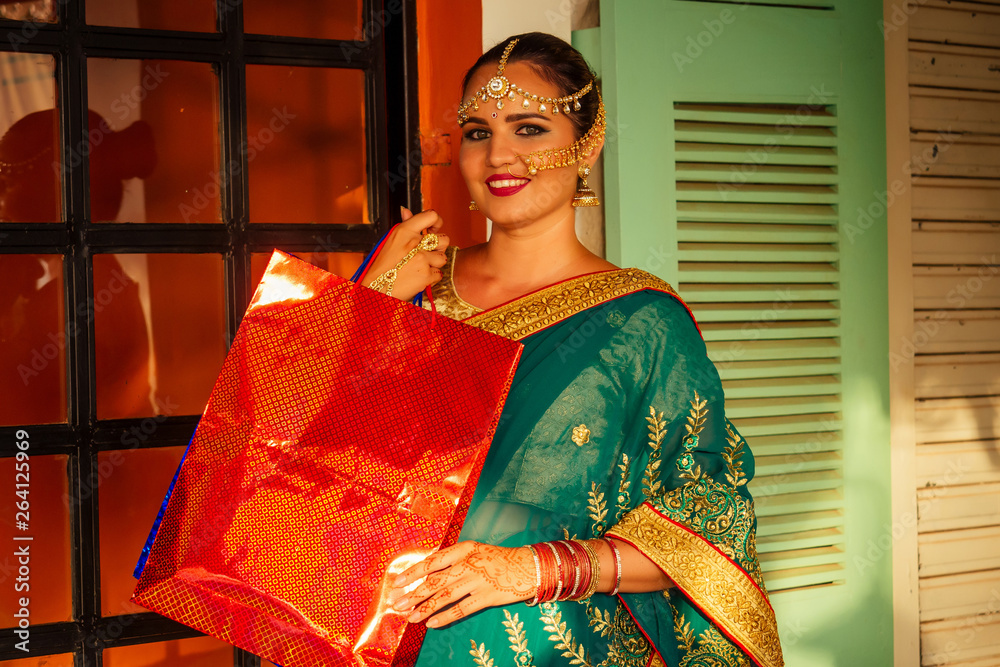 happy beautiful indian female person in traditional dress holding shop bag in market,shopping bags and credit card.black friday sales happy beautiful indian female person in traditional dress holding shop bag in market,shopping bags and credit card.black friday sales