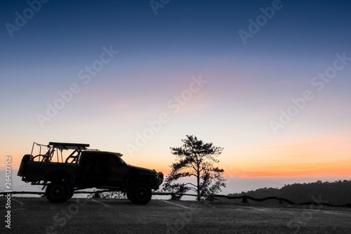Mountain view evening, silhouette of a 4WD. Truck parking on top hill with colorful vivid sky background, sunset at Huai Nam Dang National Park, Chiang Mai, northern of Thailand. © Yuttana Joe