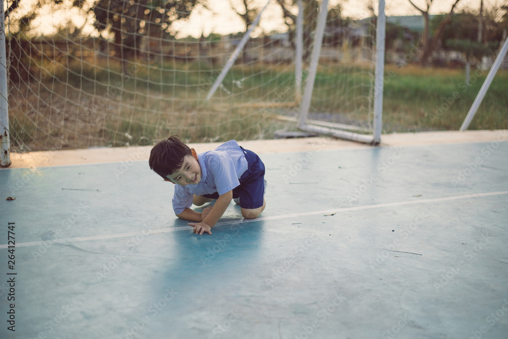 Outdoor portrait of a happy Asian student kid in school uniform smiling.