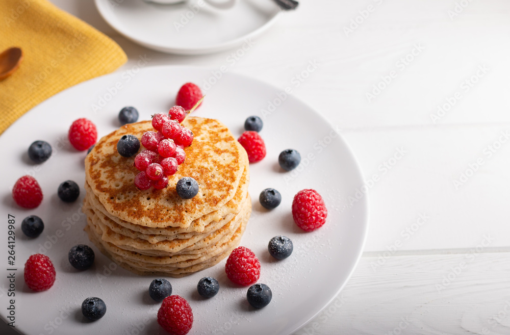pancakes with raspberries and blueberries on a white background pancakes with raspberries and blueberries on a white background
