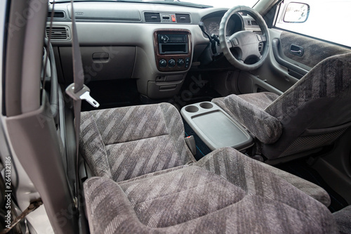 View to the gray color interior of suv car with front seats, steering wheel and dashboard  with striped fabric upholstery after cleaning and detailing in the vehicle repair workshop © Aleksandr Kondratov