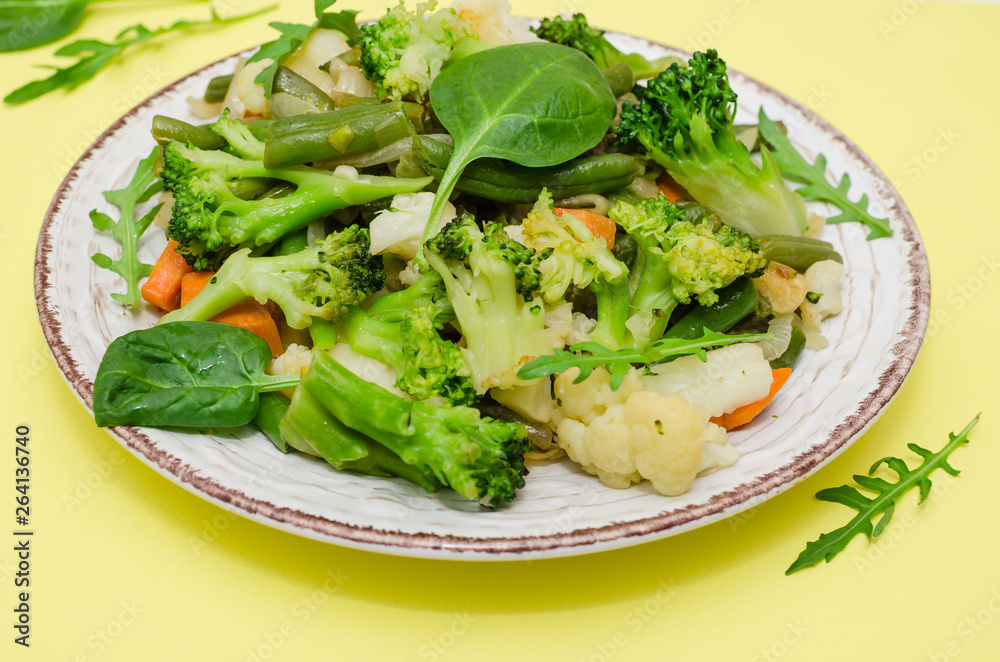 Vegetable stew on the plate on yellow background. Top view Vegetable stew on the plate on yellow background. Top view