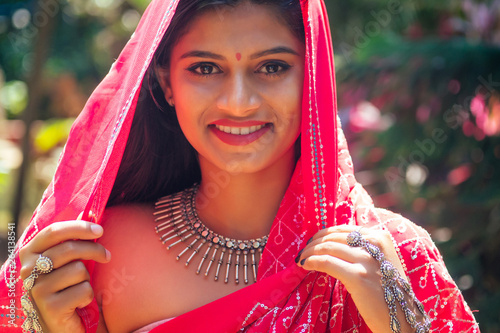 portrait of attractive indian female model in vacation on paradise tropical beach by ocean sea. hindu woman with kundan jewelry set traditional India costume red wedding sari.asian girl sensual look photo