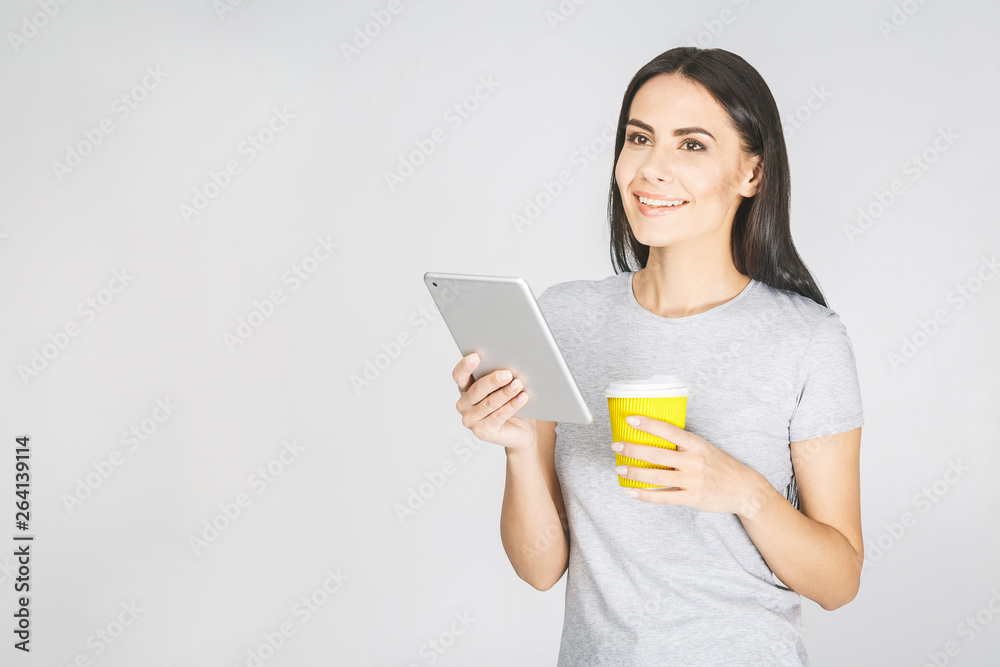 Portrait with copy space empty place of pretty charming confident trendy woman in casual having tablet in hands and drinking coffee isolated on white background. Portrait with copy space empty place of pretty charming confident trendy woman in casual having tablet in hands and drinking coffee isolated on white background.