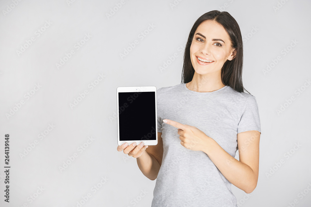 Portrait with copy space empty place of pretty charming confident trendy woman in casual having tablet in hands looking at camera isolated on white background.