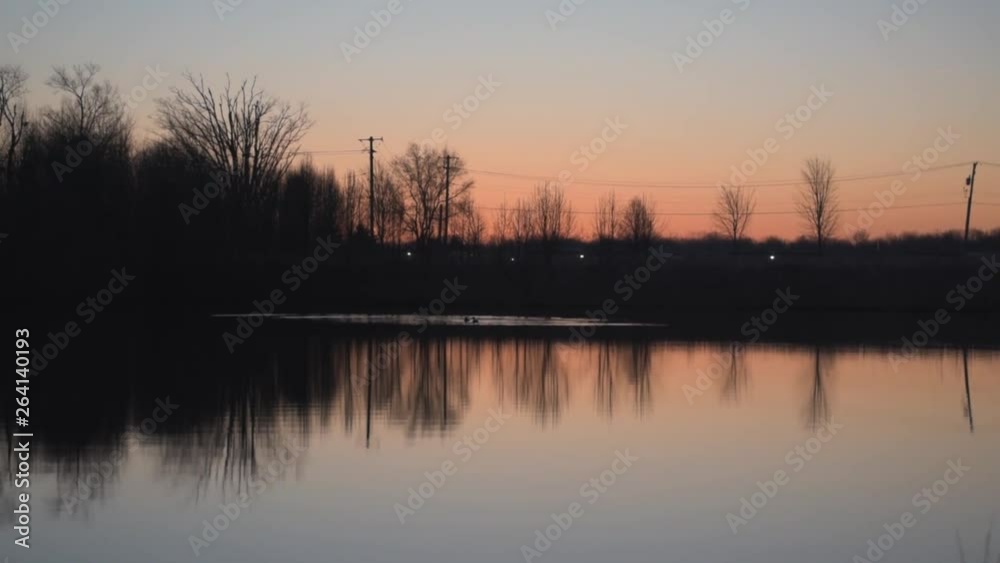 Early morning sunrise in the sky along with a pond-front reflection and some geese swimming. Early morning sunrise in the sky along with a pond-front reflection and some geese swimming.