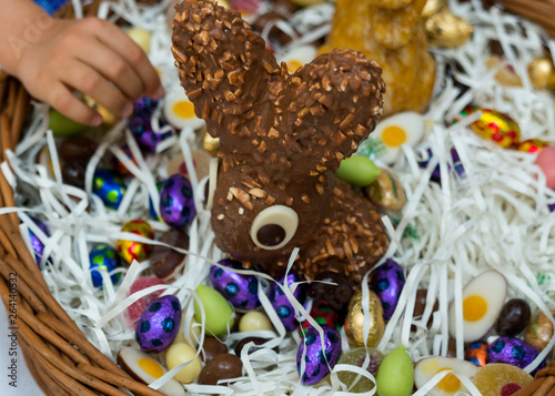many children hands reach for sweets candy and chocolate in an Easter egg basket during Easter