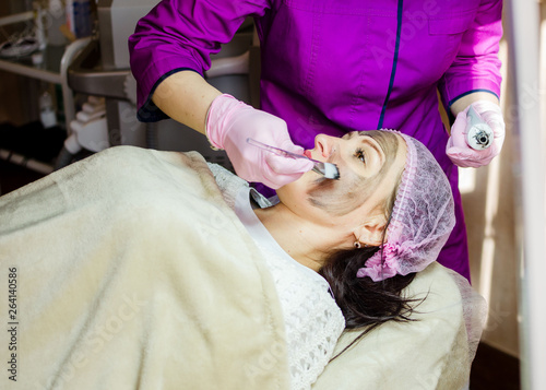 Facial skin rejuvenation.woman with carbon nanogel on her face in salon. Peeling procedur photo