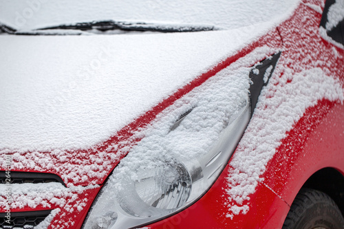 ein  Schicht Schnee auf der Motorhaube und auf dem Scheinwerfer photo