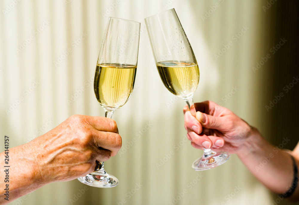 hand of eldery woman and young woman toasting with glasses of champagne