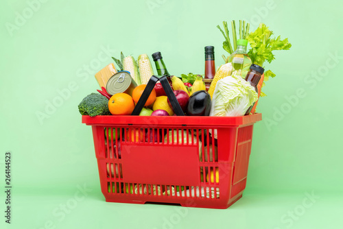 Colorful food and groceries in red supermarket plastic basket photo