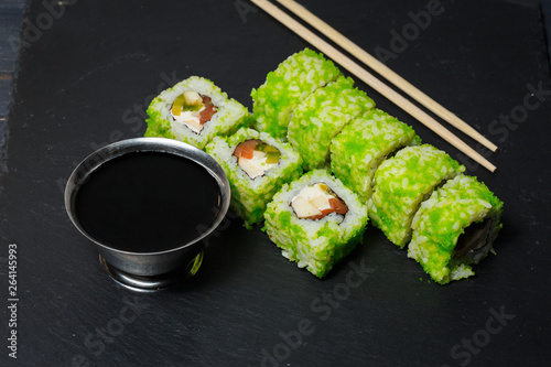 Japanese sushi rolls with tuna and cream cheese served on black stone slate