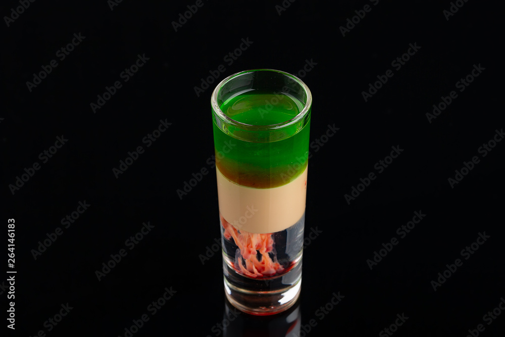Green alcoholic shot glass with absent, irish cream, liquor on elegant dark black background. Green alcoholic shot glass with absent, irish cream, liquor on elegant dark black background.