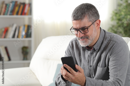 Adult man using a smart phone at home
