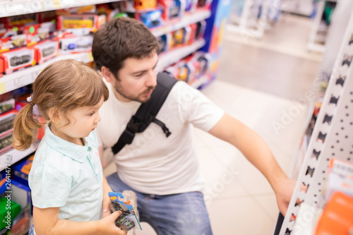 RUSSIA, Moscow. July 03, 2018. Little kid girl shopper and her father choosing toys at the toy shop