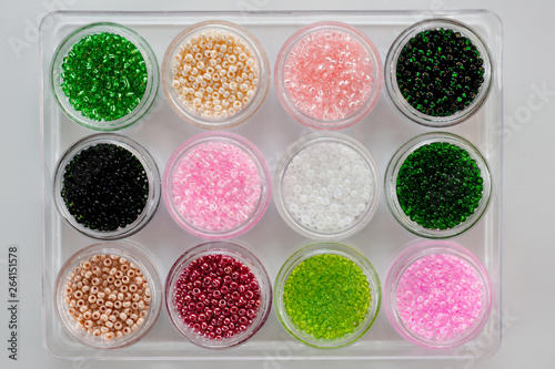 Set of multicolored beads for embroidery and needlework in plastic jars