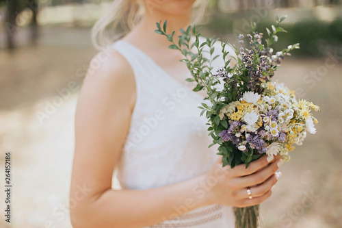 Wedding bouquet of wildflowers. The bride holds a wedding bouquet in her hands.