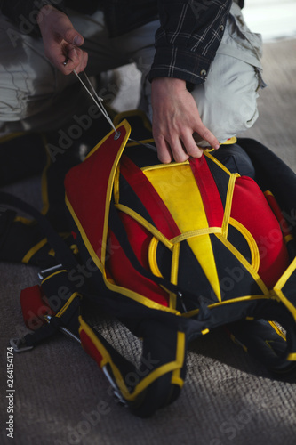 Rigger is packing parashute before jumping in the aerodrome room close-up. Face is not visible. Parachute equipment. photo