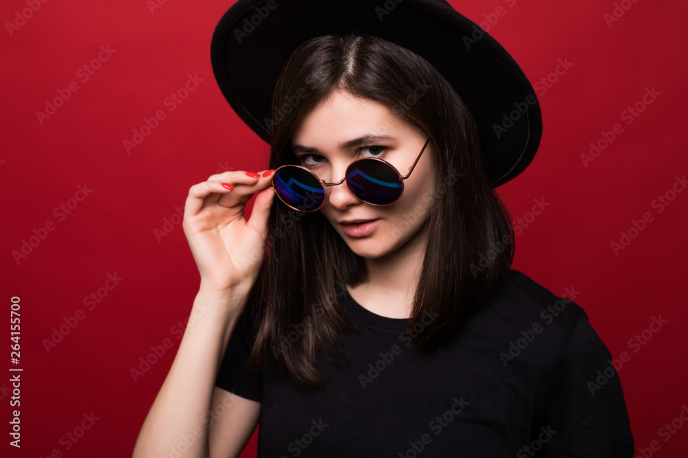 Young pretty woman in black rock style having fun over red background Young pretty woman in black rock style having fun over red background