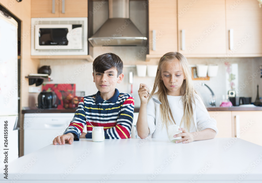 Obraz premium Happy children eating a yogurt.