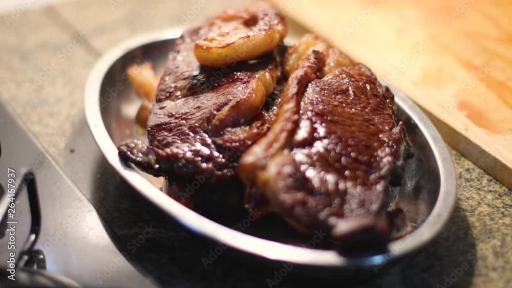 Slow focus pull on a dish of grilled sirloin steaks sitting on a kitchen counter. Static shot. Slow focus pull on a dish of grilled sirloin steaks sitting on a kitchen counter. Static shot.