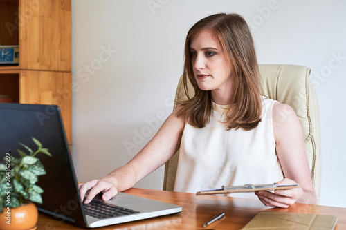 Female leader working on laptop at office