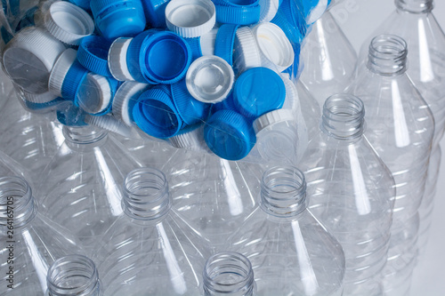 Empty plastic water and a plastic bagg full of caps ready to be recycled