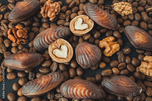  Nuts, chocolate and coffee on a black background. Walnuts in the shape of a heart. Sweets and nuts