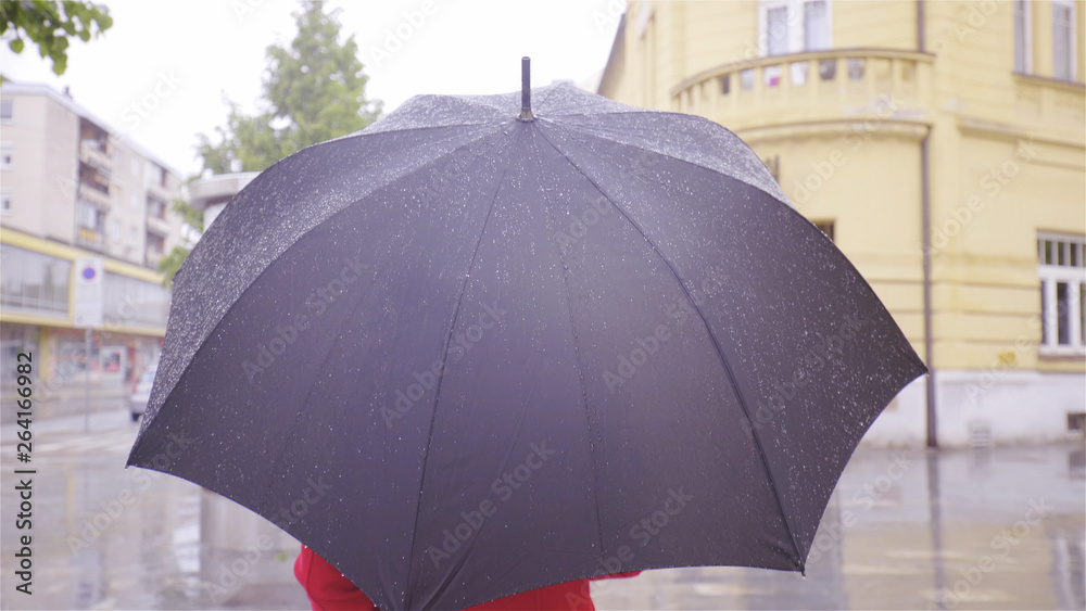 Person under the black umbrella walk in rain