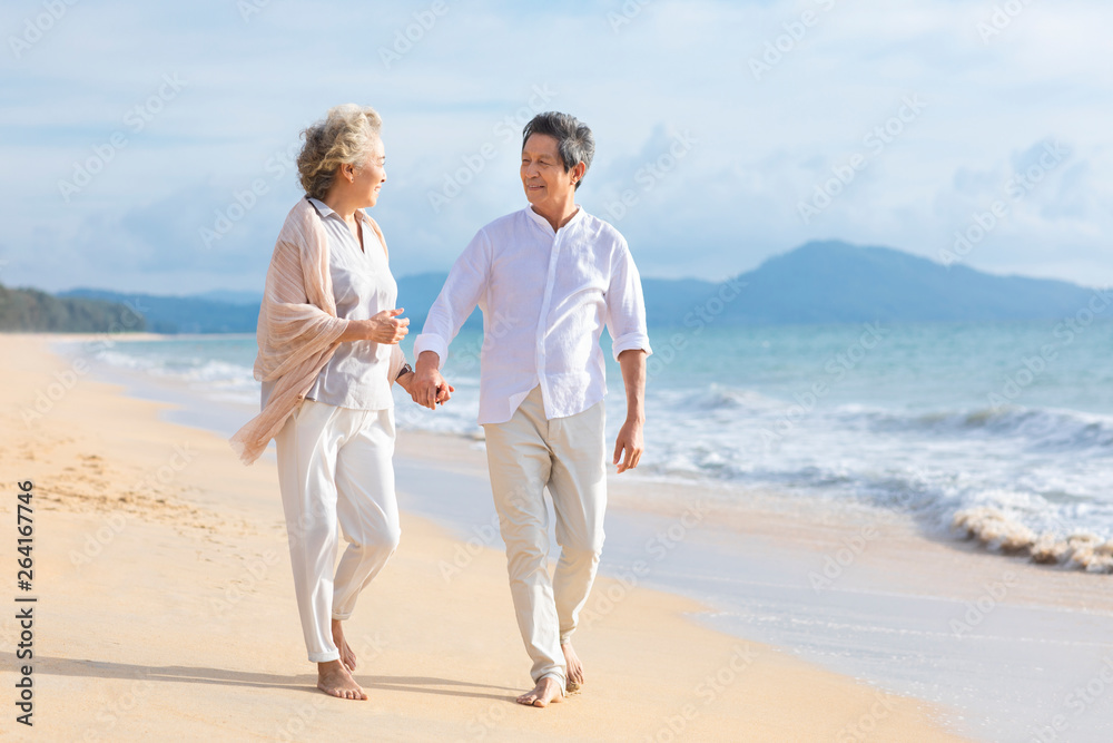 Happy senior couple walking on beach Happy senior couple walking on beach