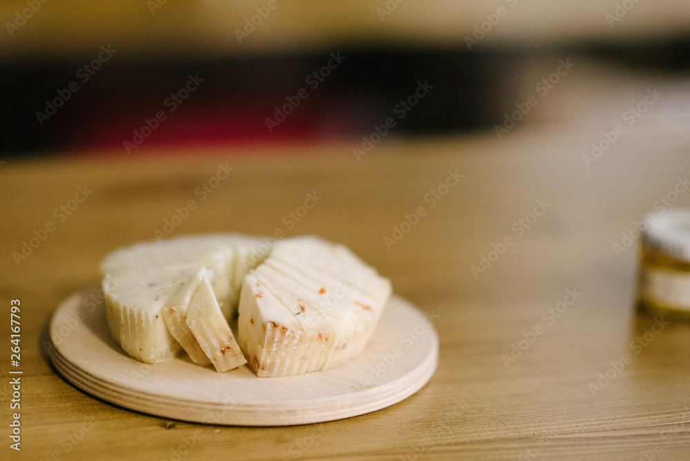 Pieces of cheese lie on a wooden tray on the table Pieces of cheese lie on a wooden tray on the table