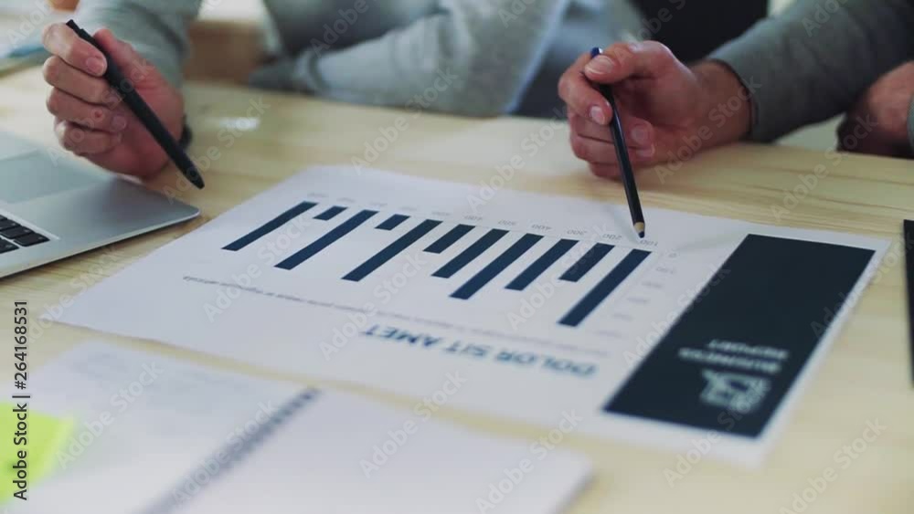 A midsection of businessman and businesswoman working together in office, talking. A midsection of businessman and businesswoman working together in office, talking.