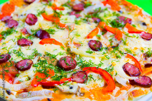 hot tasty fresh pizza on a plate close-up. green background